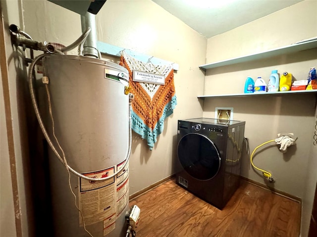 clothes washing area with wood finished floors, water heater, laundry area, washer / dryer, and baseboards