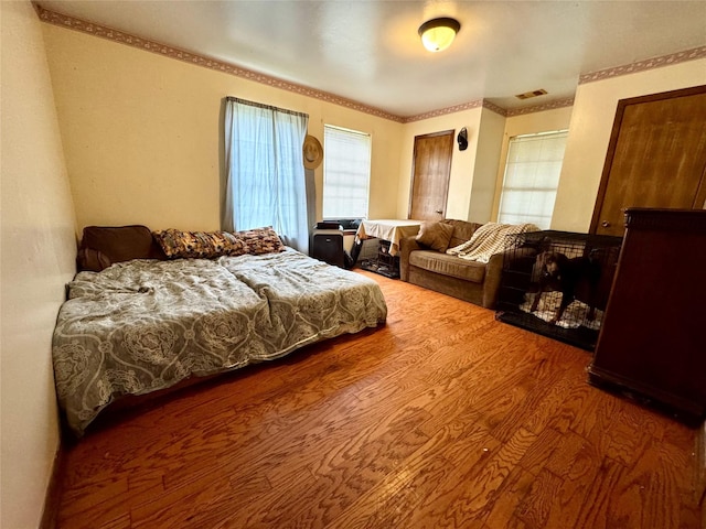 bedroom with wood finished floors and visible vents