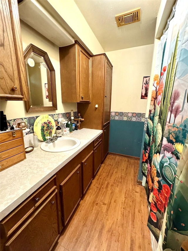 full bathroom with vanity, visible vents, and wood finished floors