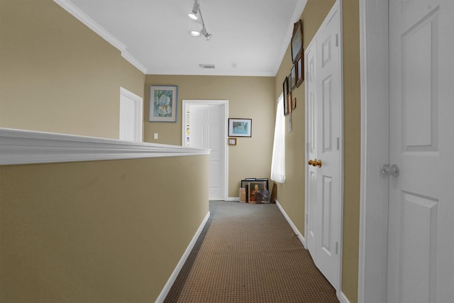 hall featuring crown molding, baseboards, dark carpet, and visible vents