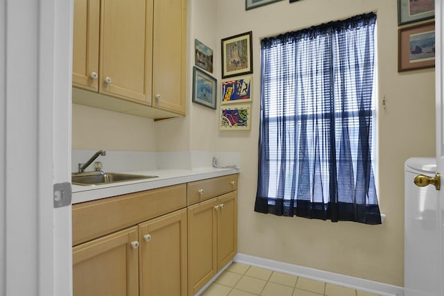 interior space with light countertops, light tile patterned floors, baseboards, and a sink