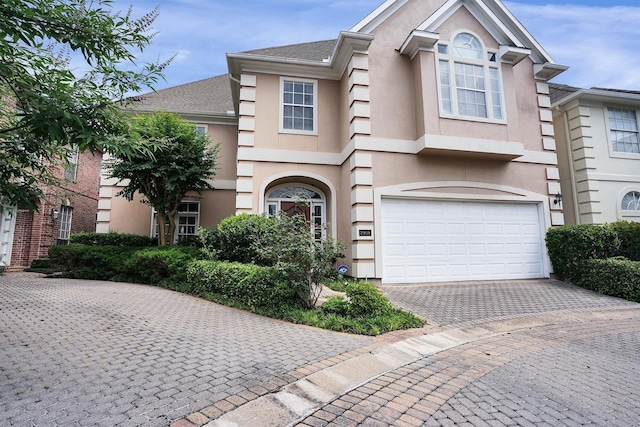 view of front of home featuring stucco siding, an attached garage, and driveway
