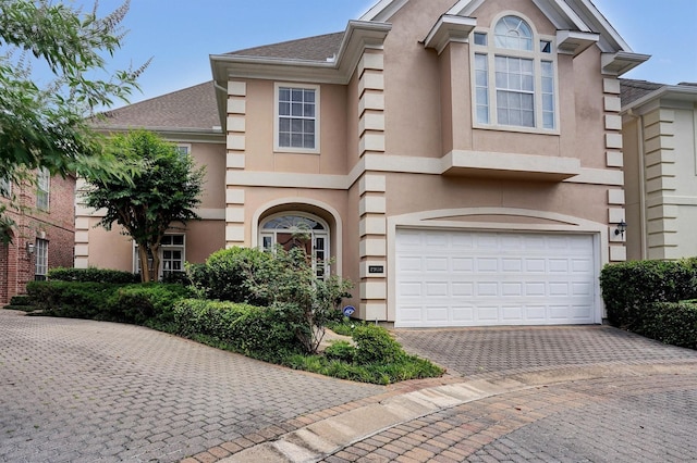 view of front of house with stucco siding, an attached garage, and driveway