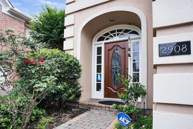 doorway to property featuring stucco siding