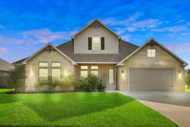 traditional-style house featuring concrete driveway, roof with shingles, an attached garage, a front lawn, and brick siding