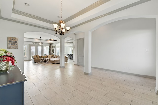 dining area featuring a raised ceiling, ceiling fan, baseboards, arched walkways, and ornamental molding