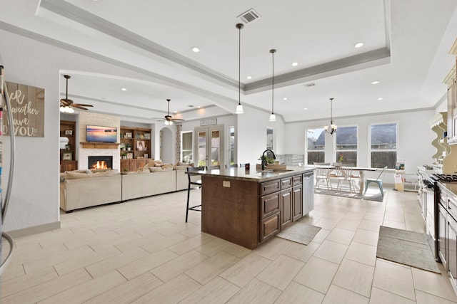 kitchen with a sink, ceiling fan, white range with gas cooktop, a tray ceiling, and dishwasher
