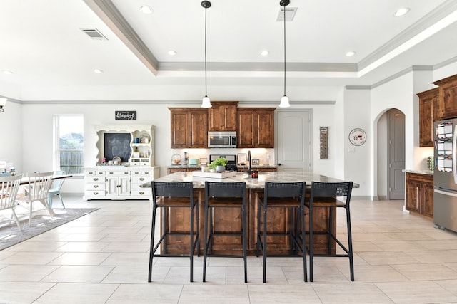 kitchen with visible vents, a raised ceiling, ornamental molding, and appliances with stainless steel finishes