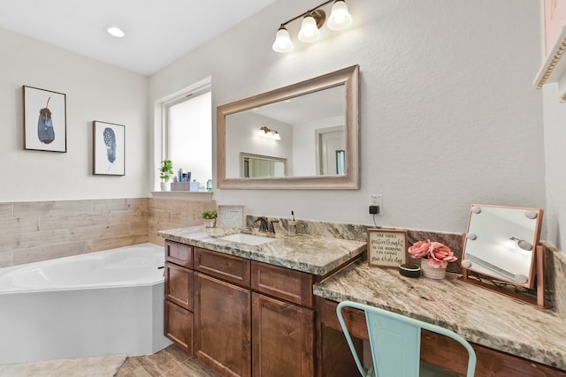 bathroom featuring vanity and a bath