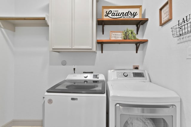 clothes washing area with independent washer and dryer and cabinet space