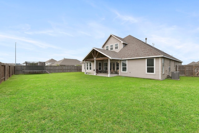 back of property featuring a patio, a trampoline, a fenced backyard, and central air condition unit