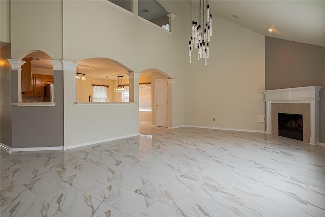11911 Timpnogos Dr, Tomball, TX 77377 - unfurnished living room featuring baseboards, high vaulted ceiling, a high end fireplace, and marble finish floor