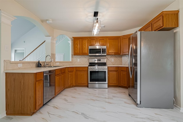 11911 Timpnogos Dr, Tomball, TX 77377 - kitchen featuring appliances with stainless steel finishes, brown cabinets, marble finish floor, and a sink