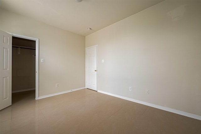 11911 Timpnogos Dr, Tomball, TX 77377 - unfurnished bedroom featuring a walk in closet, baseboards, and a closet