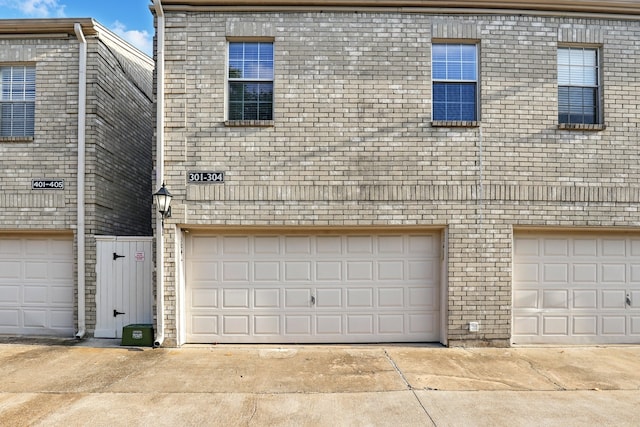view of front of home featuring brick siding and a garage