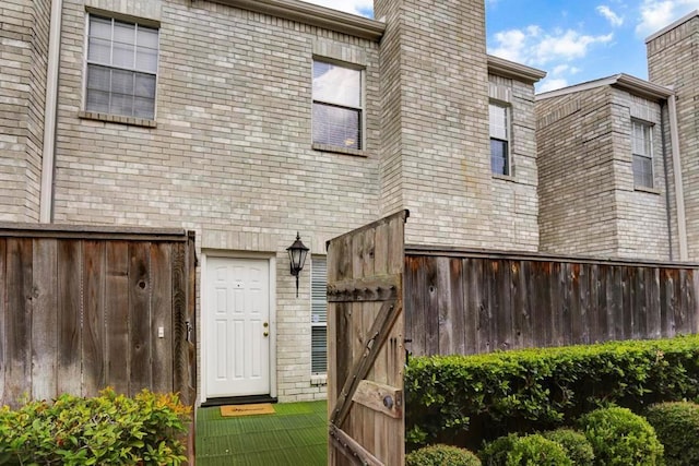 back of house with fence and brick siding