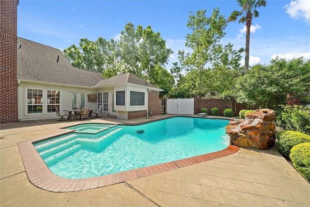 view of swimming pool featuring a patio, fence, french doors, and a pool with connected hot tub