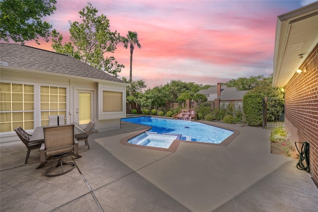pool at dusk with a fenced in pool, a fenced backyard, a patio area, and an in ground hot tub