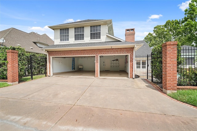 traditional-style house featuring brick siding, a gate, fence, and driveway
