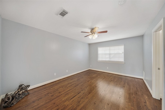 empty room featuring baseboards, a ceiling fan, dark wood-style flooring, and visible vents