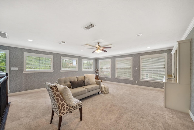 living room with crown molding, visible vents, light carpet, wallpapered walls, and a wealth of natural light