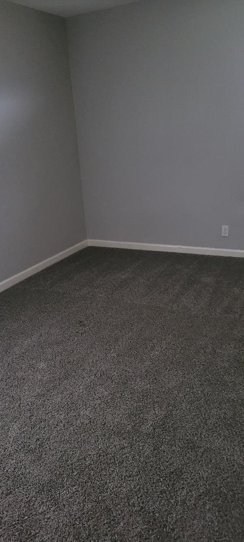 9227 Lake Park Dr, Houston, TX 77078 - spare room featuring dark colored carpet and baseboards