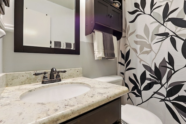 bathroom with toilet, curtained shower, and vanity