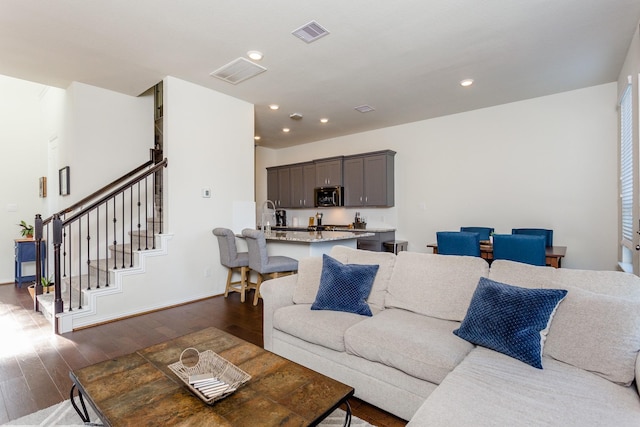 living area featuring dark wood finished floors, recessed lighting, stairs, baseboards, and visible vents