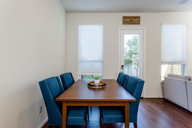 dining area with dark wood-style flooring, visible vents, and a wealth of natural light