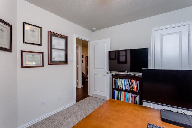 carpeted home office with baseboards