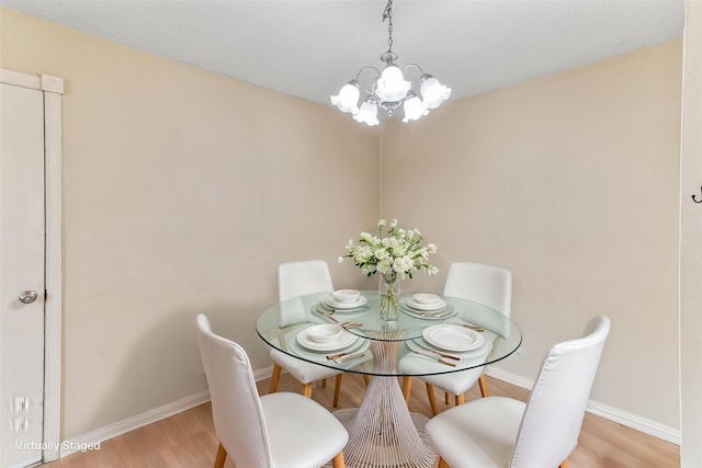 dining area with a notable chandelier, wood finished floors, and baseboards