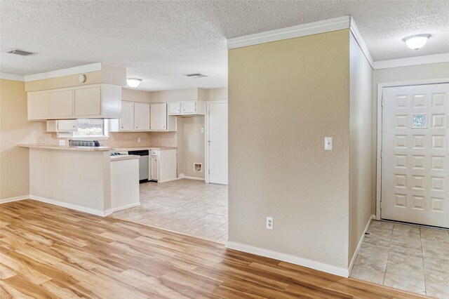kitchen featuring white cabinetry, visible vents, a textured ceiling, and a peninsula