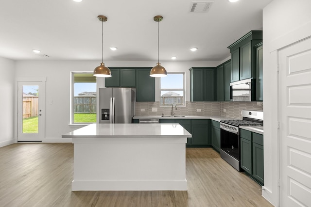 kitchen featuring visible vents, green cabinetry, stainless steel appliances, and a sink