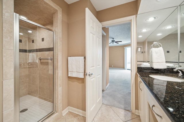 bathroom with ceiling fan, a stall shower, baseboards, tile patterned floors, and vanity