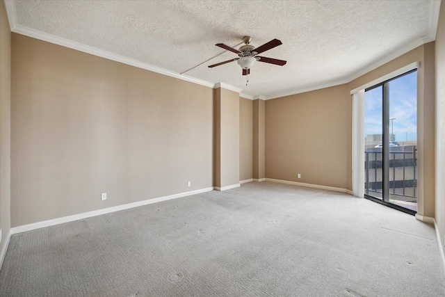 carpeted spare room with a textured ceiling, ceiling fan, ornamental molding, and baseboards
