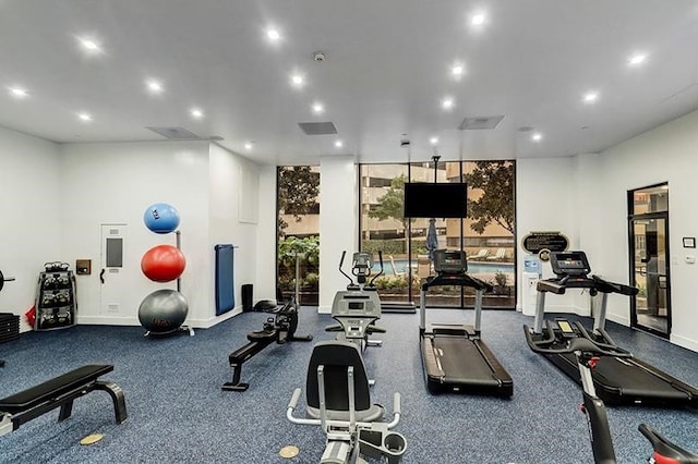 workout area featuring baseboards, recessed lighting, and expansive windows