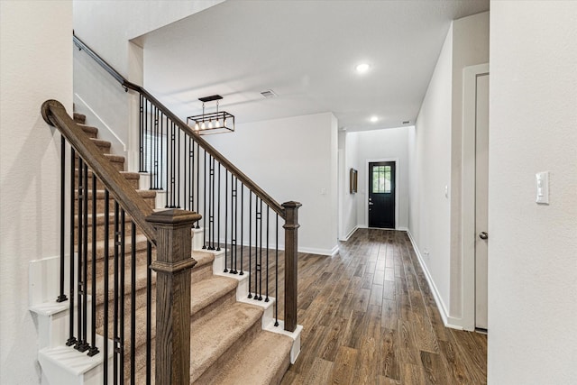entrance foyer with baseboards, dark wood finished floors, stairs, and visible vents