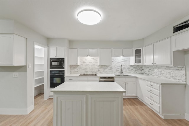 18118 Lakeside Ln, Houston, TX 77058 - kitchen featuring black appliances, a sink, light wood-type flooring, and backsplash