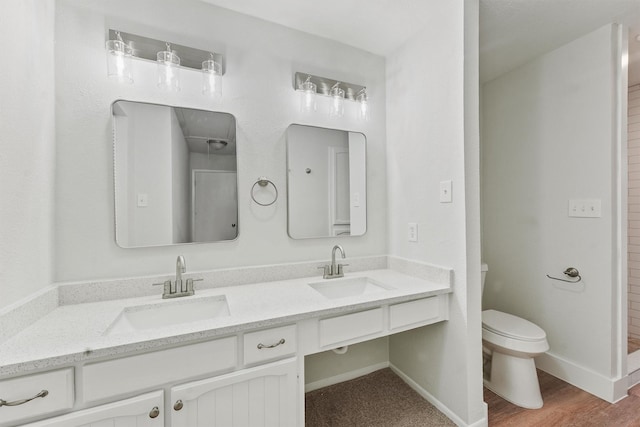 18118 Lakeside Ln, Houston, TX 77058 - bathroom with double vanity, toilet, baseboards, and wood finished floors