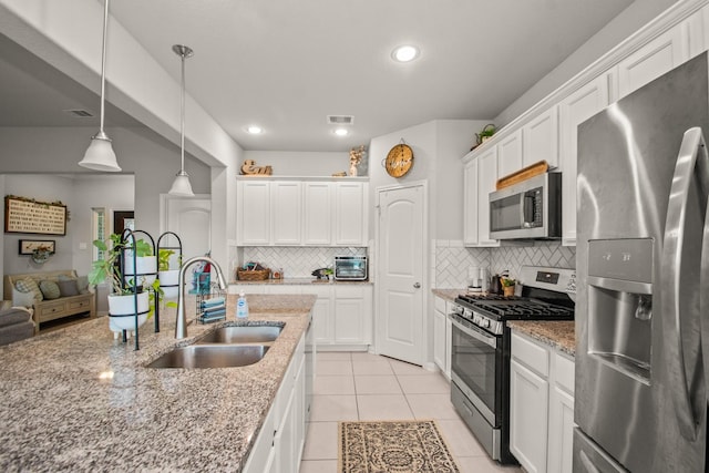 kitchen featuring tasteful backsplash, a sink, appliances with stainless steel finishes, and visible vents