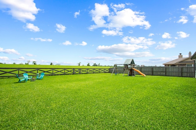 view of yard featuring a playground and a fenced backyard