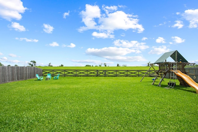 view of yard featuring fence and a playground