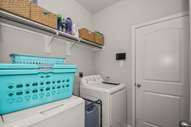 clothes washing area with separate washer and dryer and laundry area