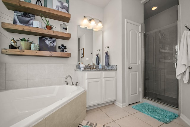 full bathroom with tile patterned floors, a bath, vanity, baseboards, and a stall shower