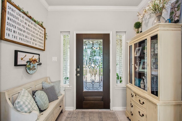 entryway with ornamental molding and baseboards