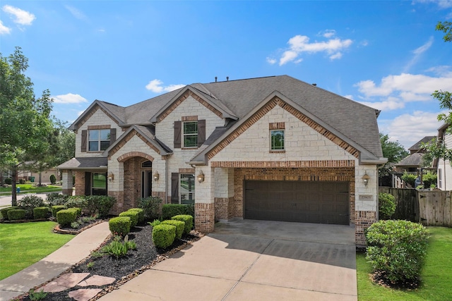 27803 Indigo Pointe Ln, Katy, TX 77494 - french country inspired facade with stone siding, driveway, a shingled roof, and an attached garage
