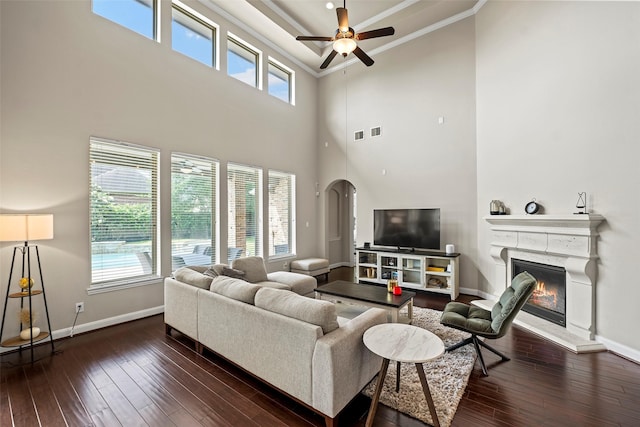 27803 Indigo Pointe Ln, Katy, TX 77494 - living area with baseboards, dark wood-style floors, a ceiling fan, arched walkways, and a high ceiling