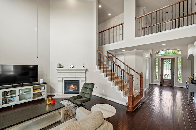 27803 Indigo Pointe Ln, Katy, TX 77494 - living room with a towering ceiling, baseboards, a glass covered fireplace, hardwood / wood-style floors, and stairway