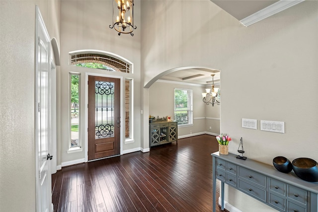 27803 Indigo Pointe Ln, Katy, TX 77494 - entrance foyer featuring a chandelier, arched walkways, dark wood-type flooring, baseboards, and crown molding