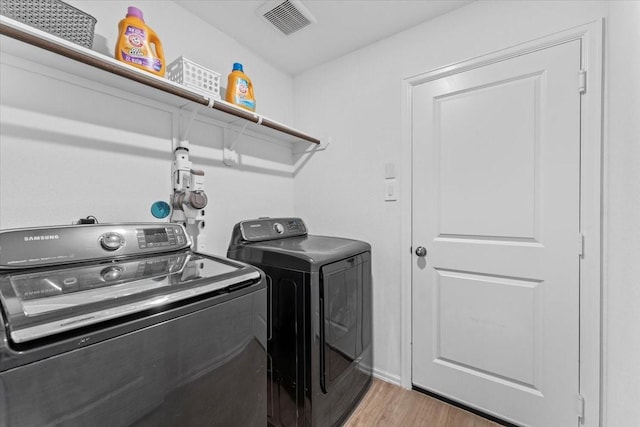 126 Spring Rose Dr, Magnolia, TX 77354 - laundry area with independent washer and dryer and wood finished floors